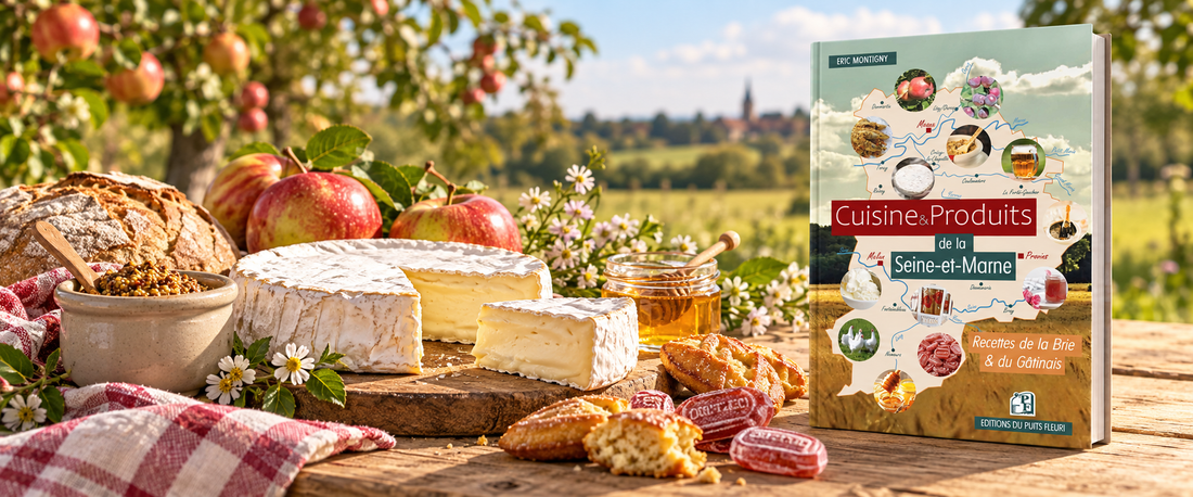 Brie entamé, pommes, pain de campagne, moutarde de Meaux, miel et coquelicots de Nemours sur une table champêtre, avec le livre « Cuisine & Produits de la Seine-et-Marne »
